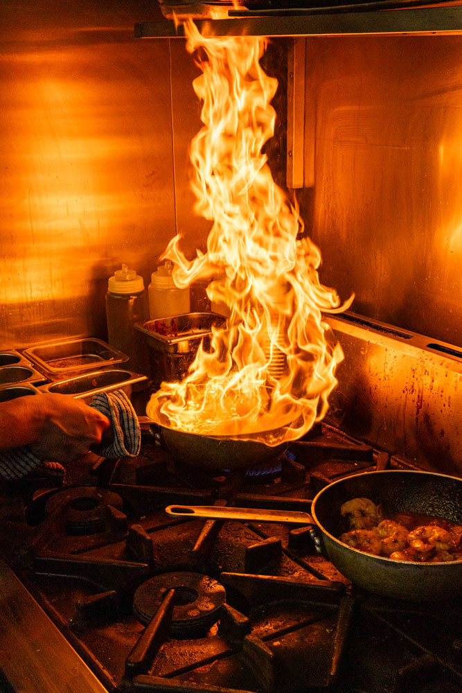A chef flambeing seafood in the Crabshack kitchen