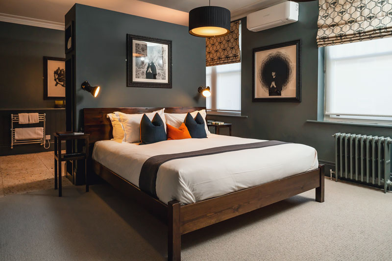A Luxury Double room with charcoal walls and warm wood