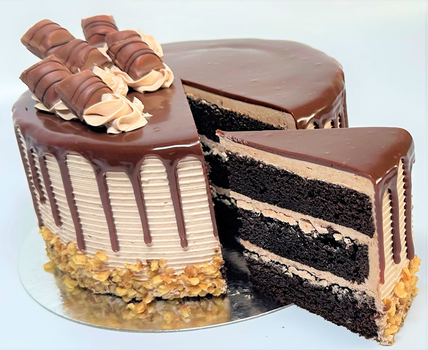 Kinder Bueno layer cake with chocolate drip, cut to show the sponge