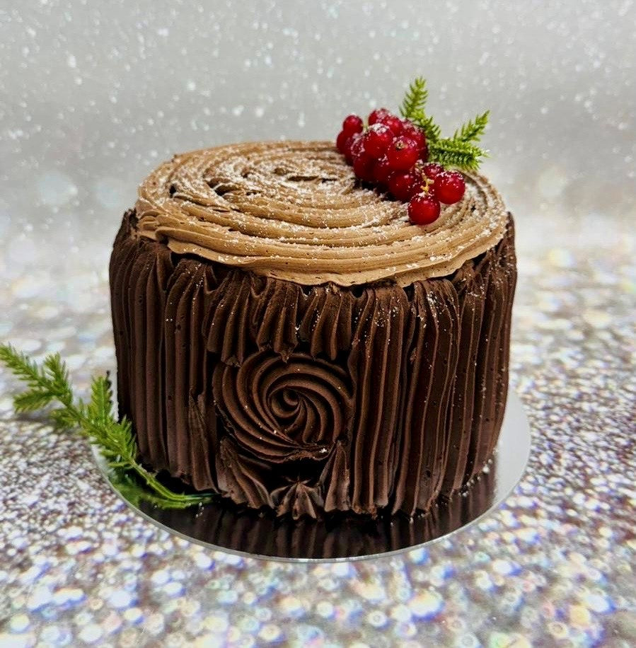 Chocolate log cake finished with buttercream bark and redcurrants